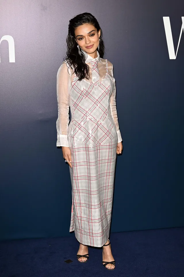 Rachel Zegler wearing a checked dress and black heeled sandals.