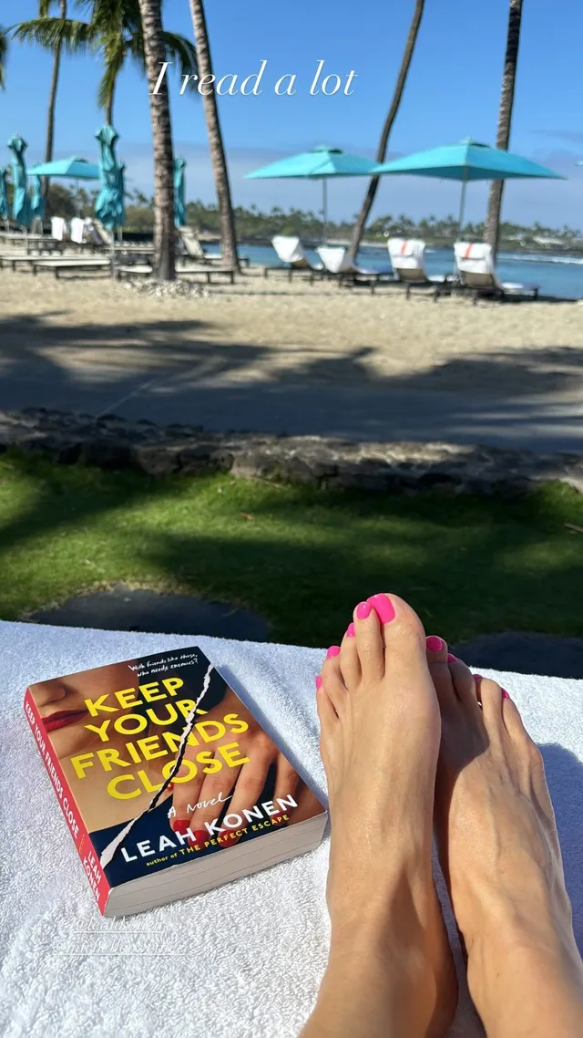 Sarah Michelle Gellar resting her bare feet beside a book on a beach lounger.