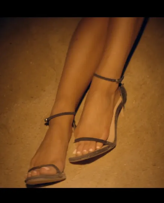 Ariana Grande wearing brown ankle-strap sandals in a close-up.