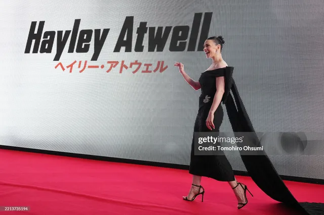 Hayley Atwell walking across a red carpet in a black gown.