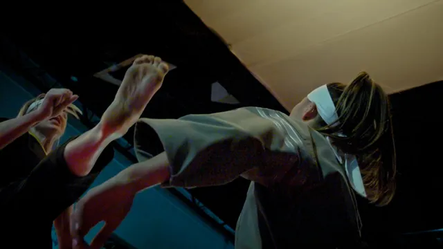 Peyton List raising bare feet during a screen scene.