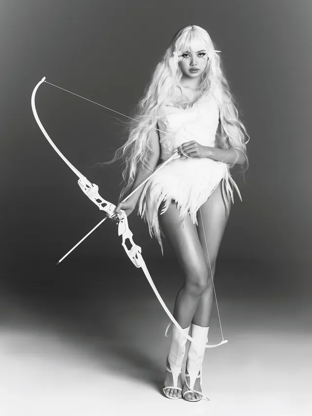 Lisa (Lalisa Manobal) posing with a bow in white heeled boots during a monochrome studio shoot.