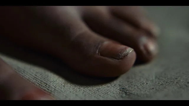 Sophie Wilde showing painted toenails in a close-up film scene.