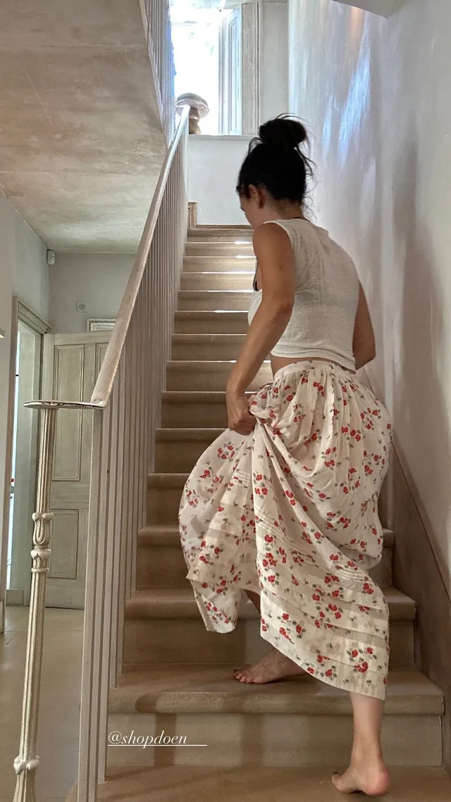 Rachel Bilson standing on stairs in a floral skirt.