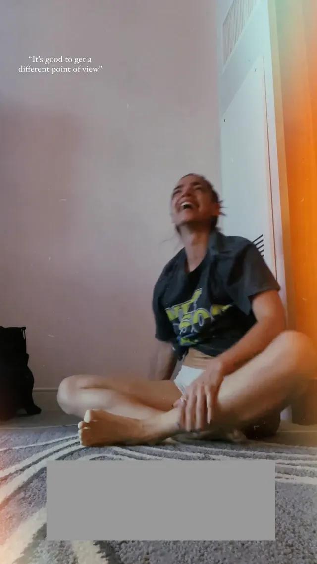 María Gabriela de Faría sitting barefoot cross-legged after exercise.