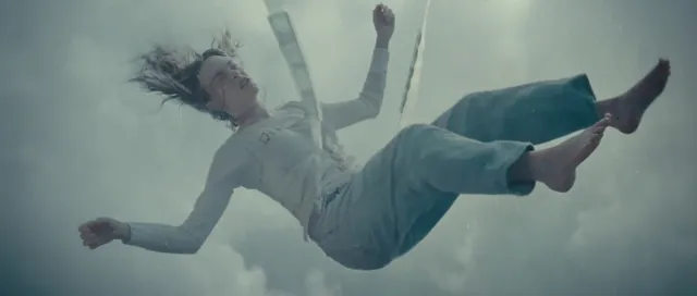 Cara Delevingne appearing suspended in a studio screen scene.