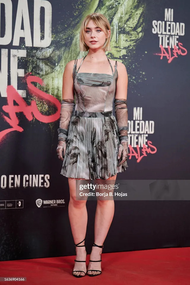 Clara Galle wearing a patterned mini dress and black heels at a premiere.