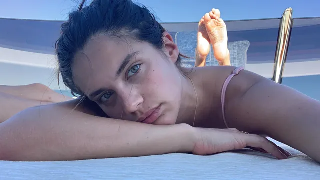 Sara Sampaio lying on a lounger with her bare feet raised.