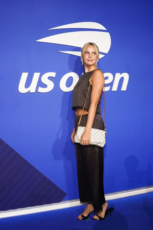 Bailee Madison wearing black heels on a blue carpet.