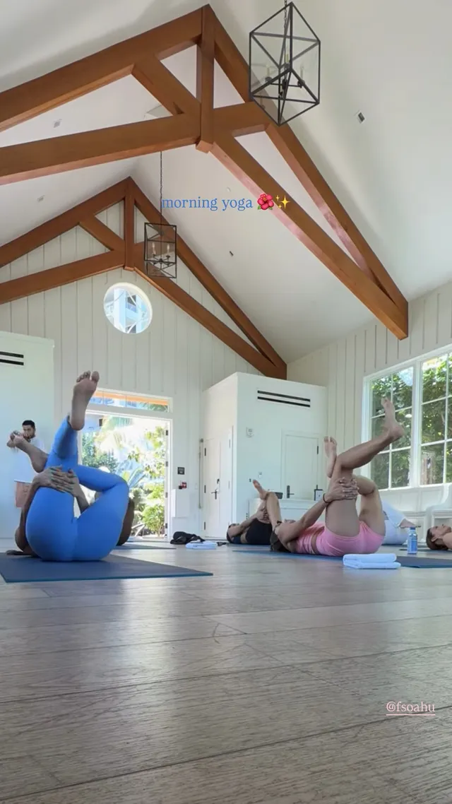 Victoria Justice stretching with a friend in a bright exercise room.