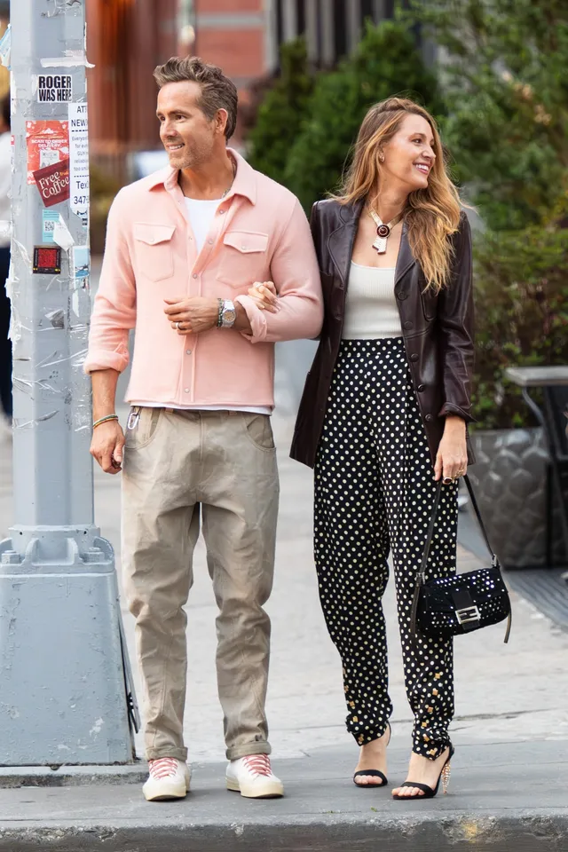 Blake Lively walking outdoors with a companion in heels.