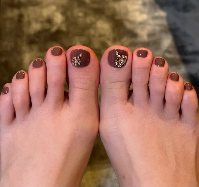 Jennifer Lopez a close-up of painted toenails outdoors.