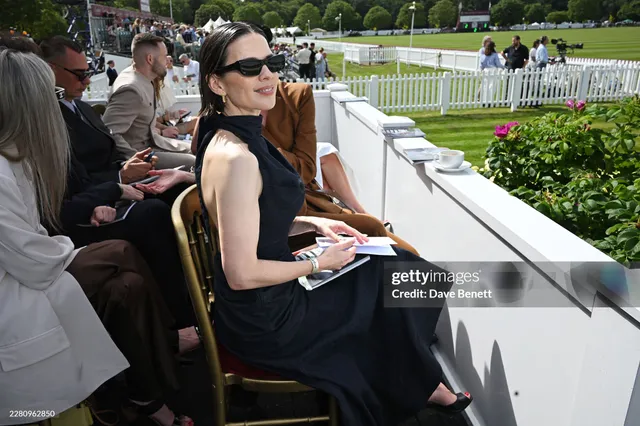 Hayley Atwell sitting among spectators at an outdoor event.