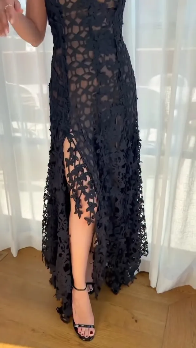 Selena Gomez wearing a black lace gown and black sandals.