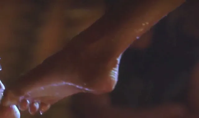 Eiza González a close screen detail of a bare foot in colored light.