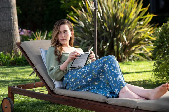 Victoria Pedretti reading on an outdoor lounger during a screen scene.