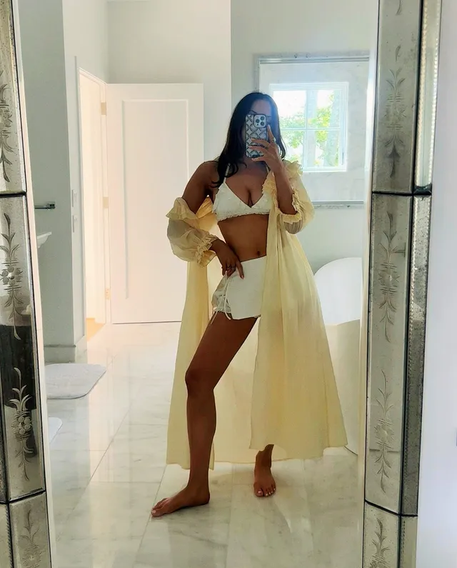 Elizabeth Gillies taking a mirror portrait in a light cover-up.