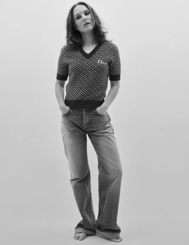 Natalie Portman standing barefoot in jeans for a monochrome portrait.