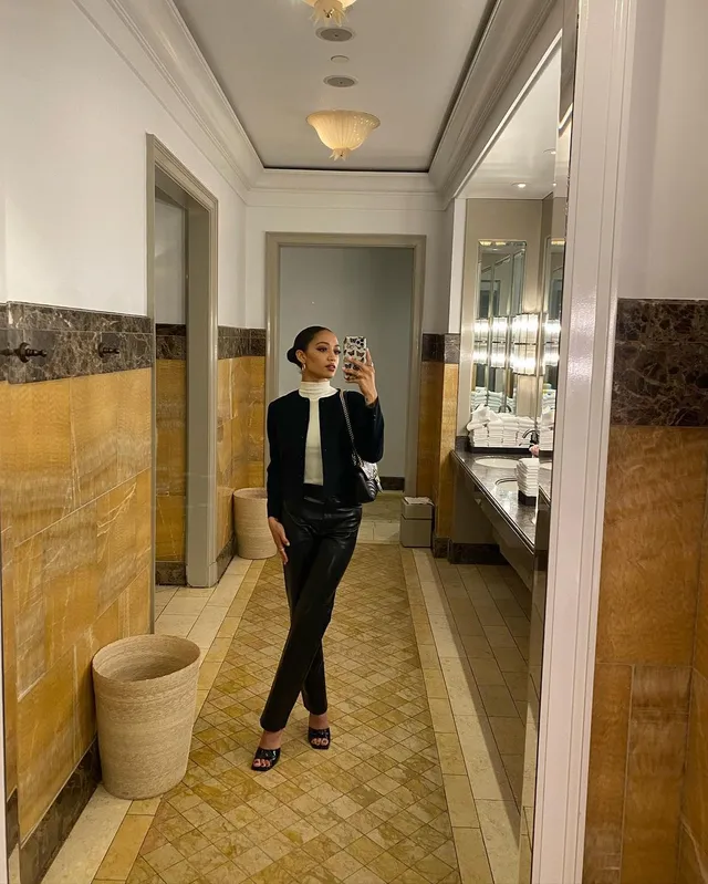 Samantha Logan taking a mirror selfie in black trousers and open-toe heels.
