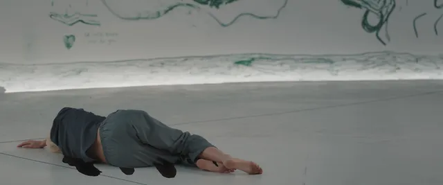 Kate Bosworth lying on a pale floor in a screen scene.