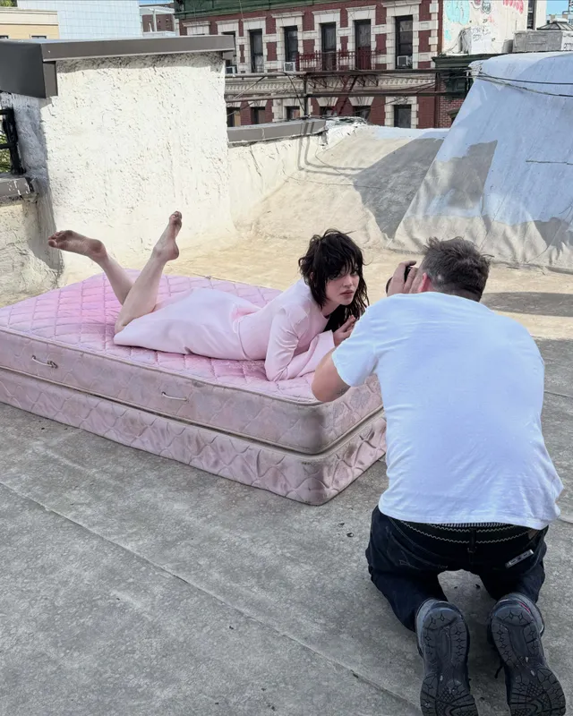 Sophie Thatcher lying on a rooftop mattress with her bare feet raised.