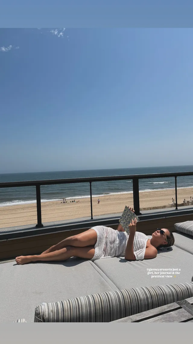 Bailee Madison lying barefoot beside a beach.