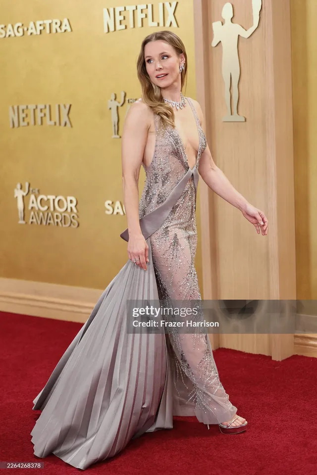 Kristen Bell walking in a flowing dress and heels at an event.