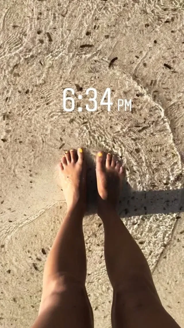 Ella Purnell standing on a sandy path.