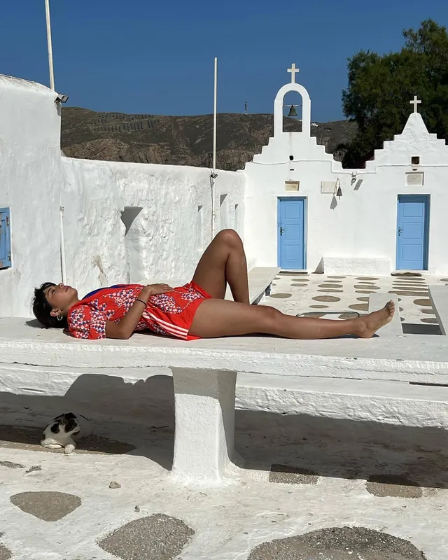Xochitl Gomez reclining barefoot on a white terrace.