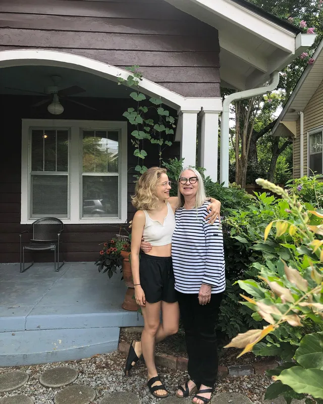 Willa Fitzgerald standing outdoors in flat sandals with a companion.