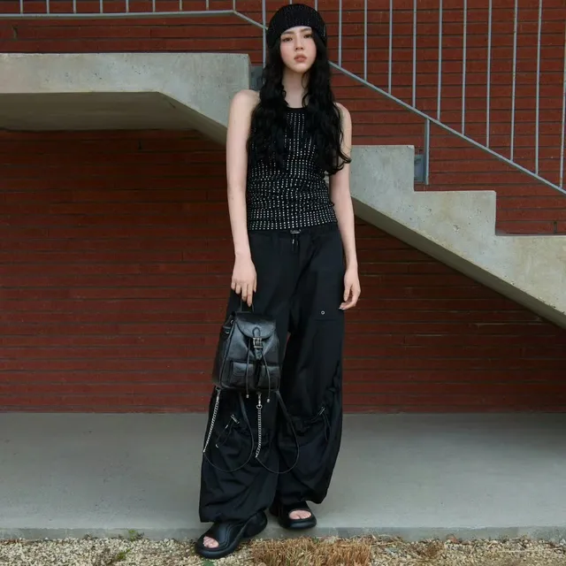 Han So-hee wearing a black outfit and sandals outdoors.