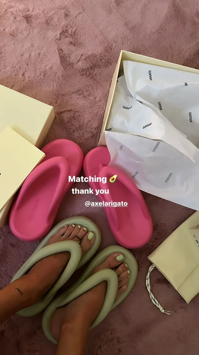 María Pedraza shown wearing green slides beside a pair of pink shoes.