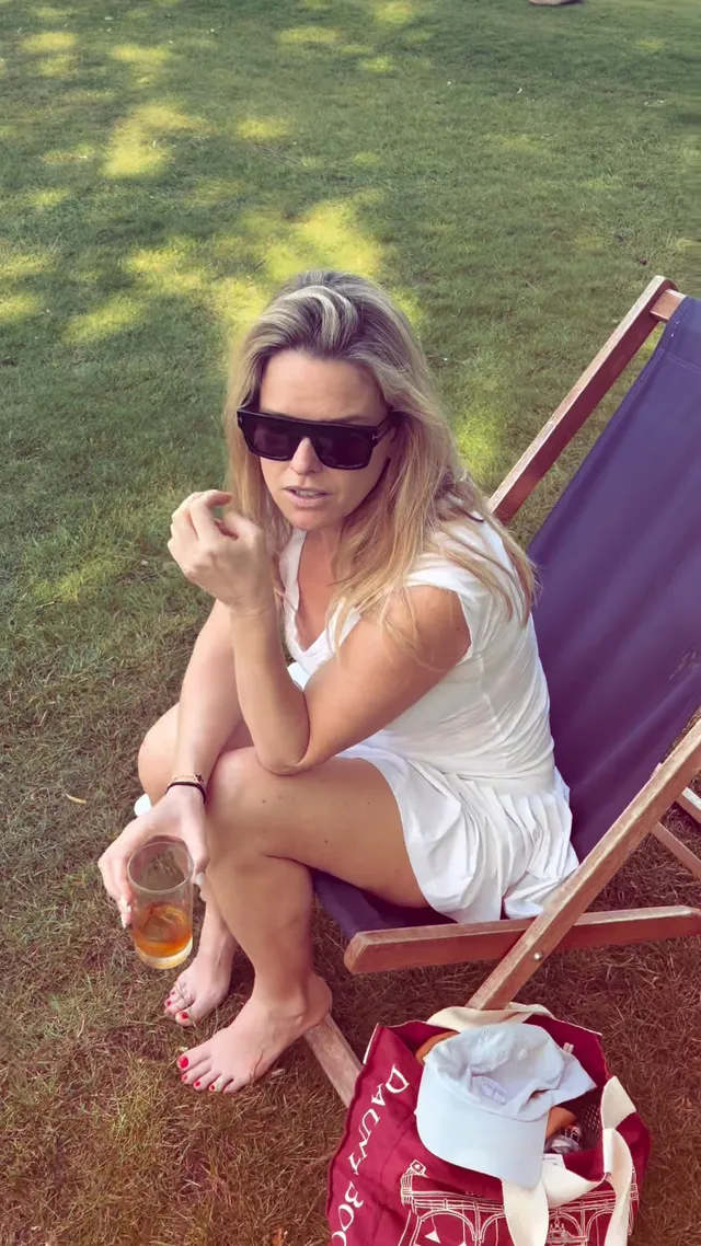 Alice Eve sitting in a garden chair holding a drink.