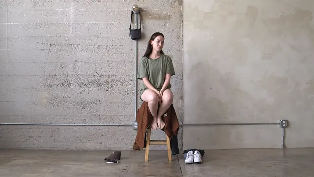Victoria Pedretti sitting on a stool during a casual portrait shoot.