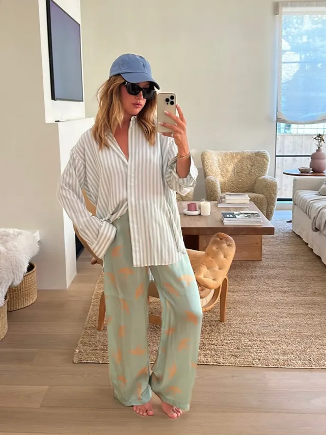 Ashley Tisdale taking a barefoot mirror photograph in striped casual clothing.