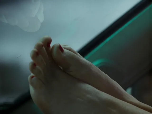 Jennifer Lawrence showing painted bare toes and a sole in a close-up.
