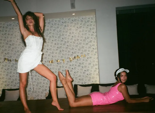 Sarah Hyland posing with a companion during a casual indoor gathering.