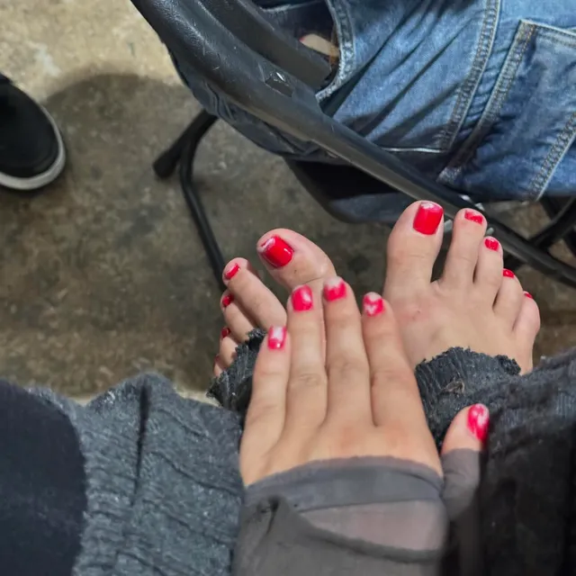 Camila Cabello showing painted bare toes beside denim and a chair.