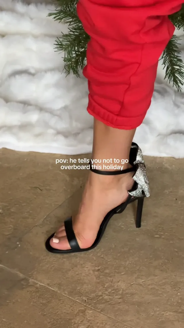 Millie Bobby Brown wearing black heels beneath red trousers.