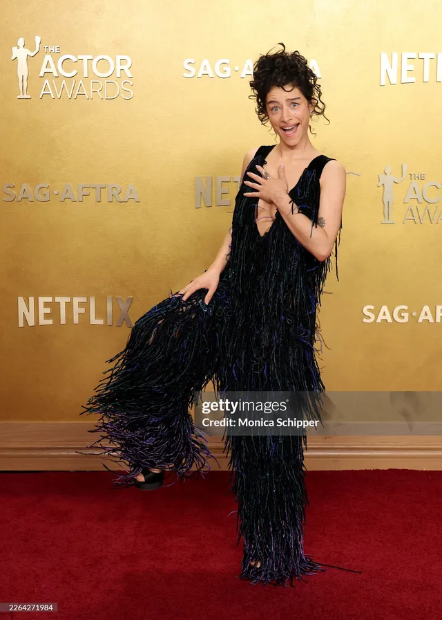 Odessa A'zion wearing a dark feathered gown at an awards event.