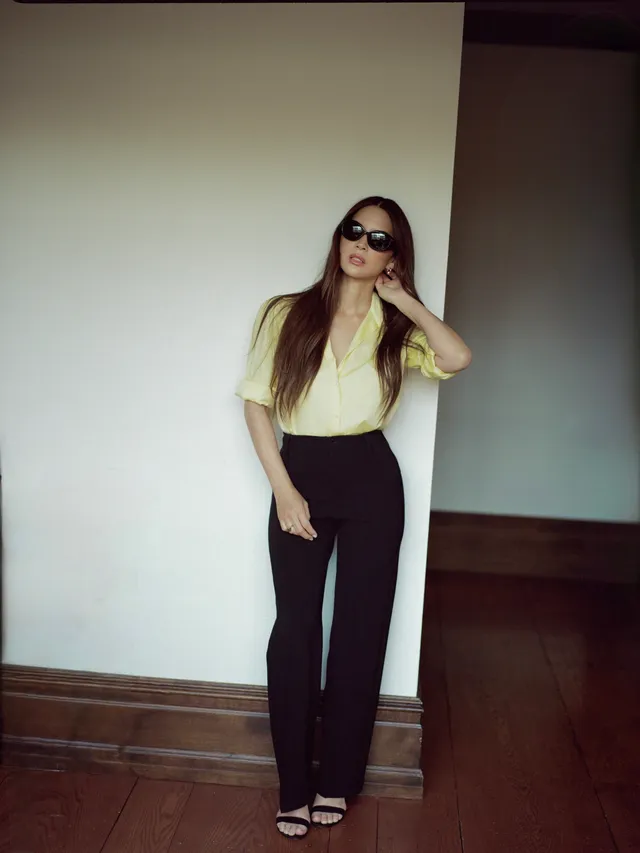Olivia Munn posing in trousers and black strappy heels.