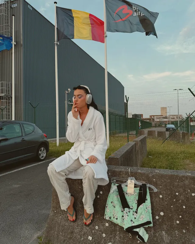 Katy Perry sitting outdoors in a white outfit.