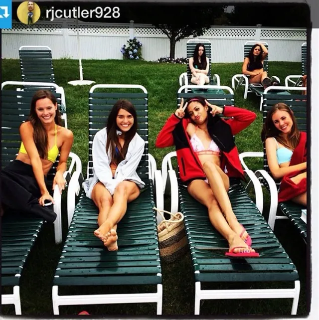 Samantha Logan reclining barefoot on a pool lounger with friends.
