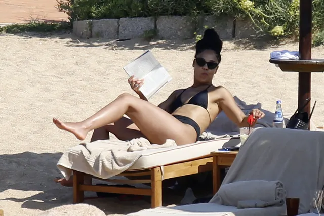 Tessa Thompson sitting on a beach lounger in sunglasses.