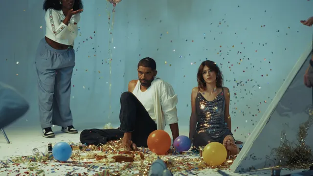 Daisy Edgar-Jones sitting beside another person in a room with balloons.