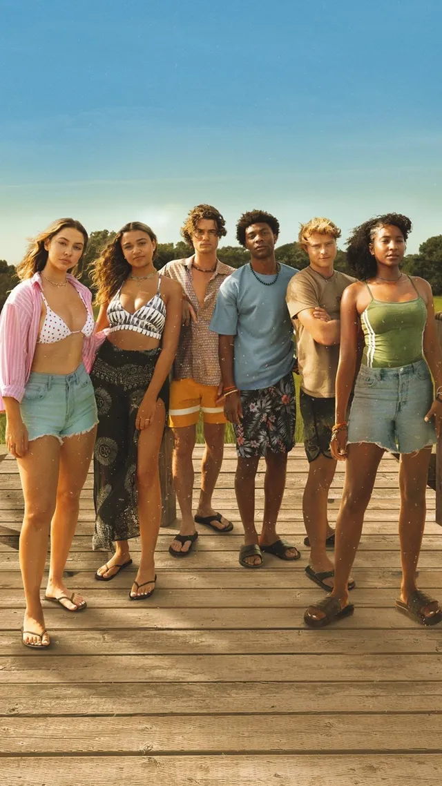 Carlacia Grant standing with fellow performers on a wooden pier in a green dress and flats.