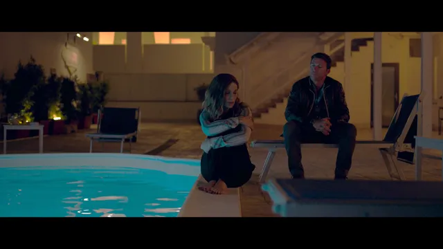 Kate Beckinsale sitting beside another person at a pool in a screen image.