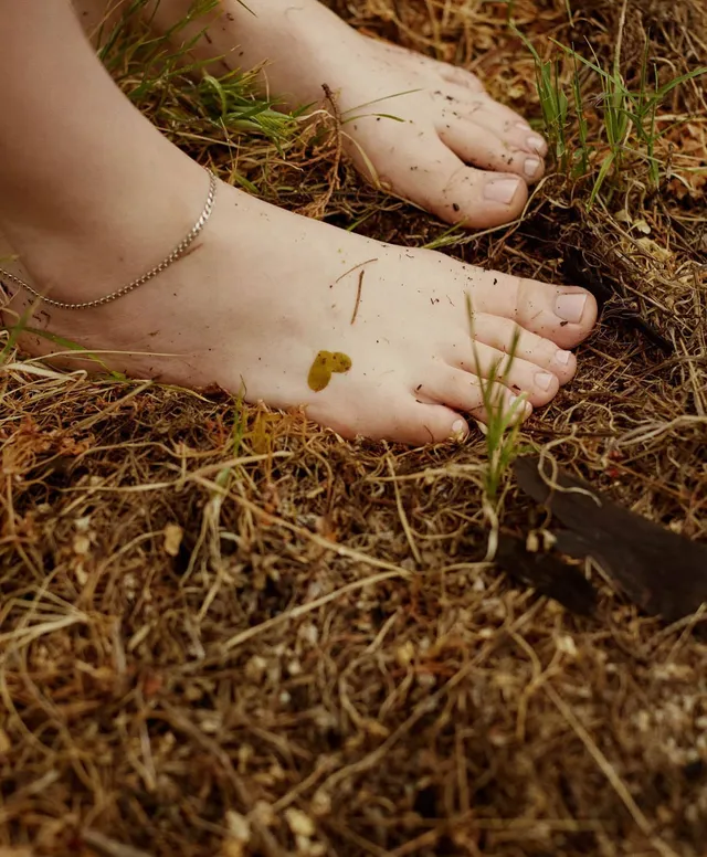 Billie Eilish bare feet resting on a woodland floor.