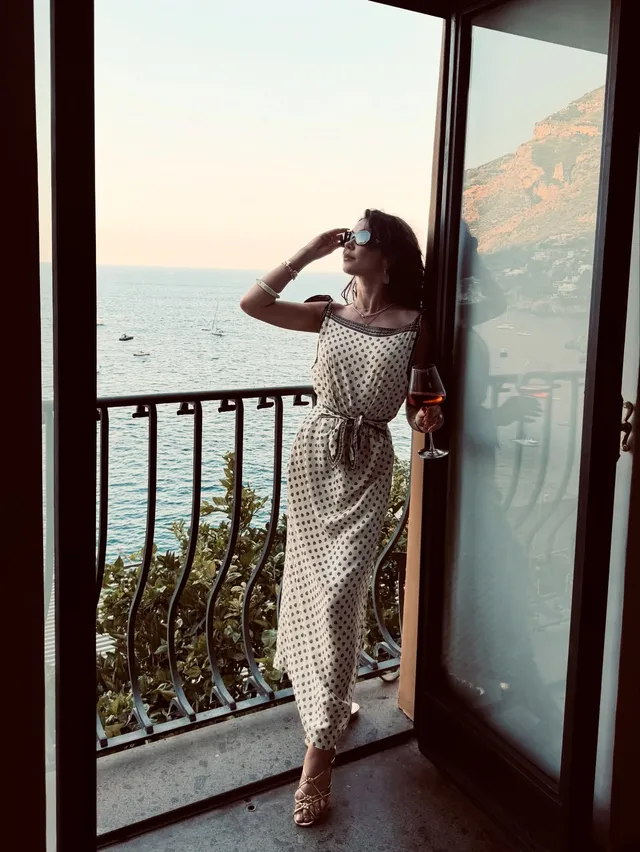 Sarah Hyland posing on a balcony in a patterned outfit.