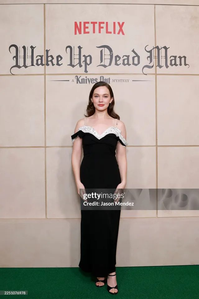 Cailee Spaeny wearing a long black dress and black heels at a premiere.